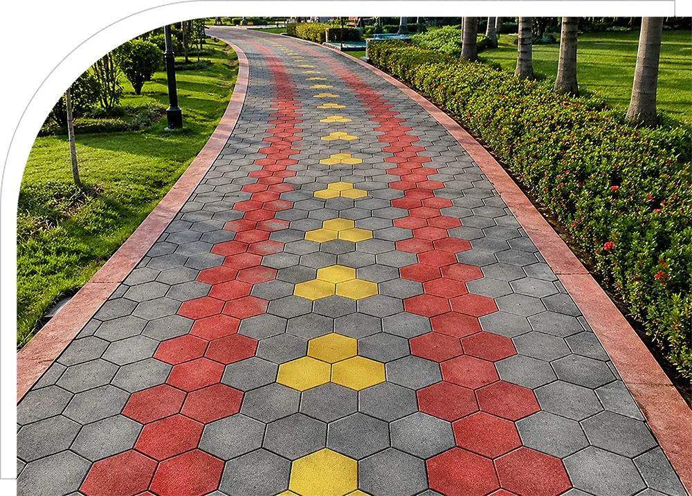 A modern outdoor paving area featuring decorative hexagonal concrete pavers in a stylish black and grey pattern with landscaped garden surroundings